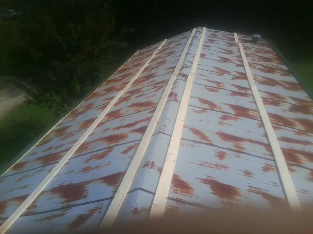 Rusted metal roof panels with new wood purlins before replacement — Storm Damage Roof Repair in Collinsville by Roofing Brothers